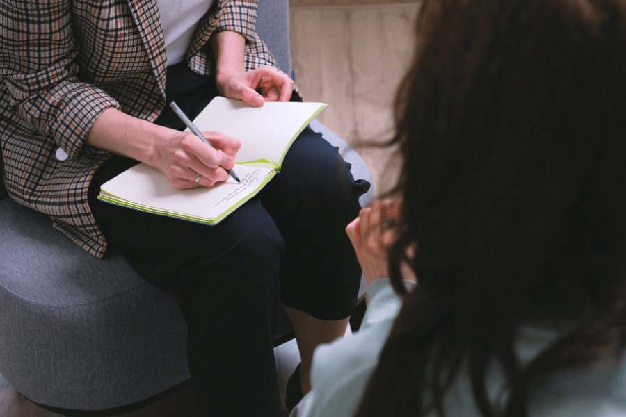 counselor writing in a notebook during appointment