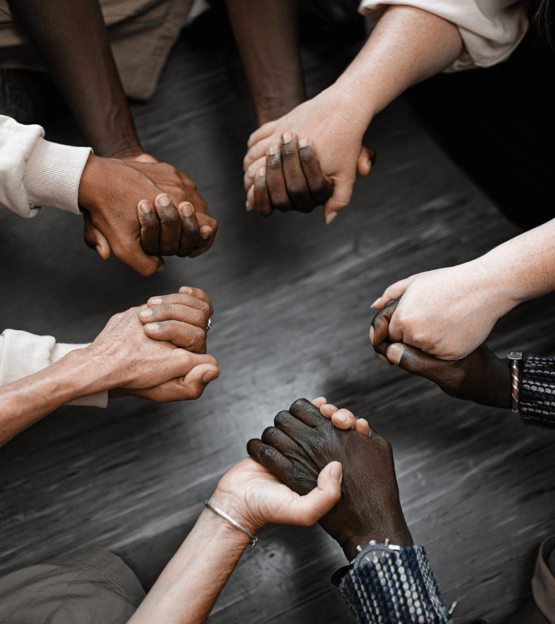 people holding hands in a circle